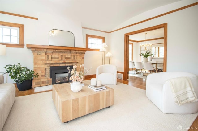 living room featuring a healthy amount of sunlight, a fireplace, and crown molding