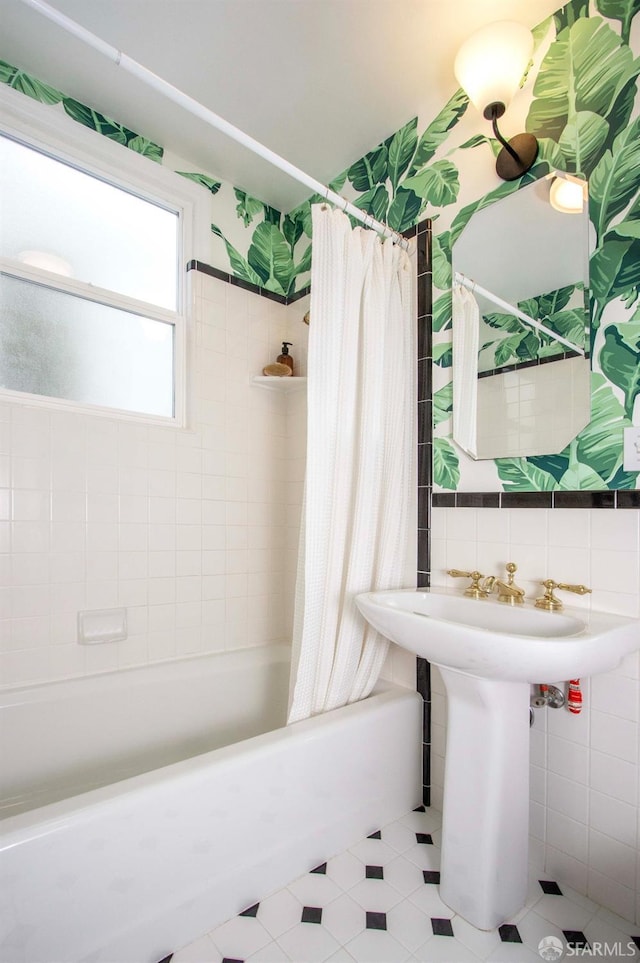 bathroom featuring tile patterned flooring, tile walls, shower / bath combination with curtain, and decorative backsplash