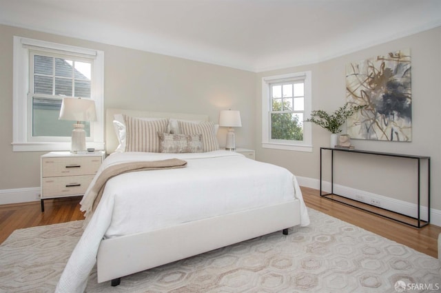 bedroom with wood finished floors and baseboards