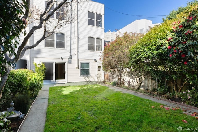 rear view of property featuring a yard