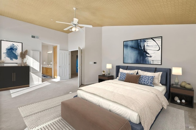 bedroom with ensuite bathroom, carpet flooring, ceiling fan, and high vaulted ceiling