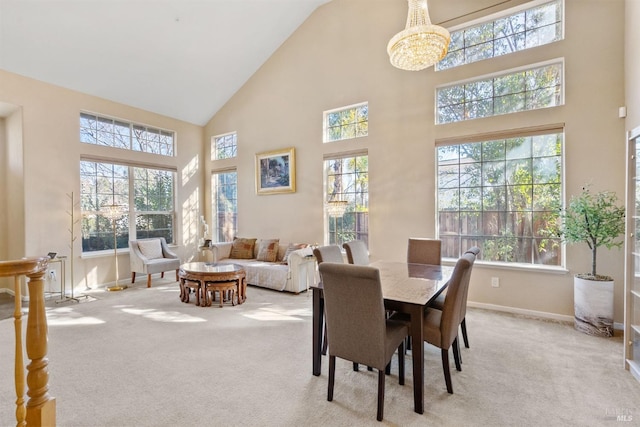 carpeted dining space with high vaulted ceiling and a chandelier