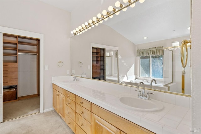 bathroom with vanity, a washtub, and vaulted ceiling