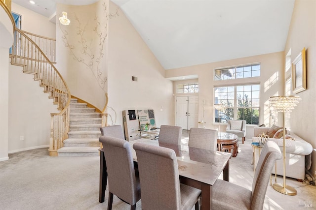 dining area with light colored carpet and high vaulted ceiling