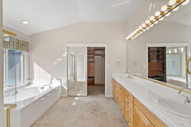 bathroom featuring vanity, independent shower and bath, and vaulted ceiling