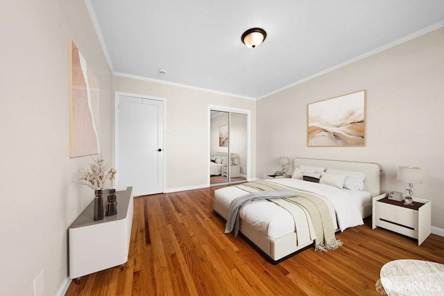 bedroom featuring ornamental molding, baseboards, and wood finished floors