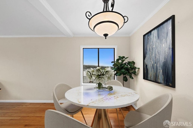 dining space with baseboards, wood finished floors, and ornamental molding