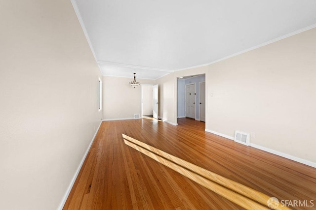 interior space featuring baseboards, visible vents, and wood finished floors