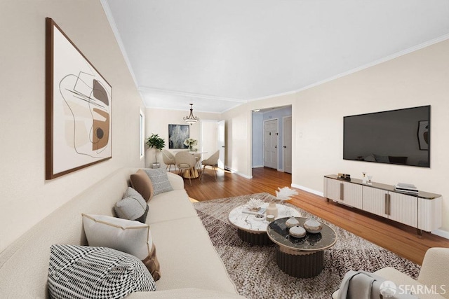 living area with crown molding, baseboards, and wood finished floors