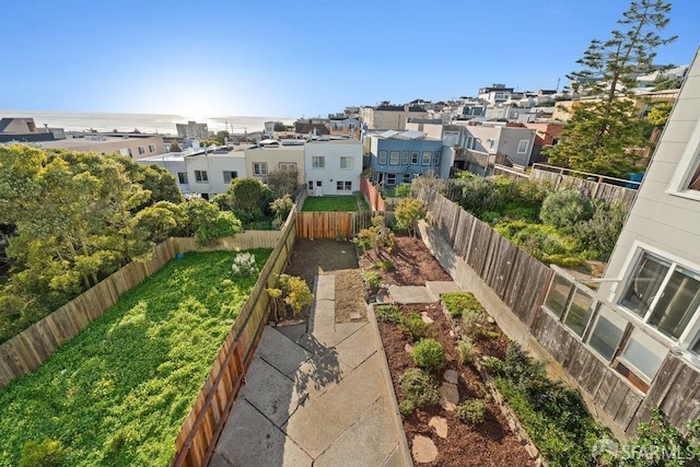 exterior space featuring a residential view, a fenced backyard, and a vegetable garden