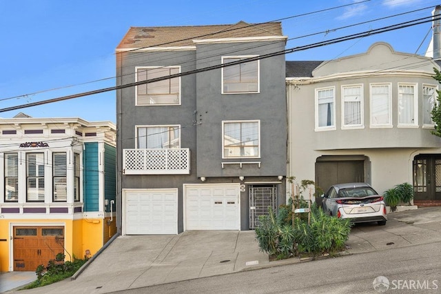 multi unit property with driveway, a garage, and stucco siding