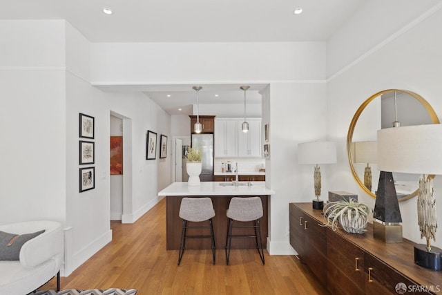 1500 Mcallister St Unit A, San Francisco, CA 94115 - kitchen with stainless steel refrigerator, a kitchen bar, light wood-style floors, a sink, and a peninsula