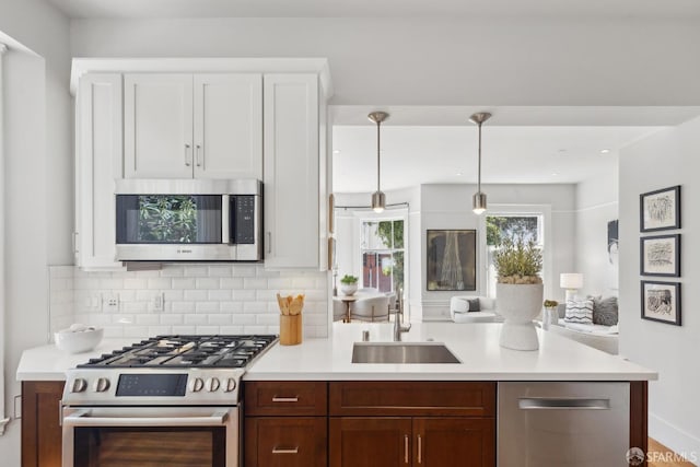 1500 Mcallister St Unit A, San Francisco, CA 94115 - kitchen featuring stainless steel appliances, a sink, light countertops, tasteful backsplash, and a peninsula