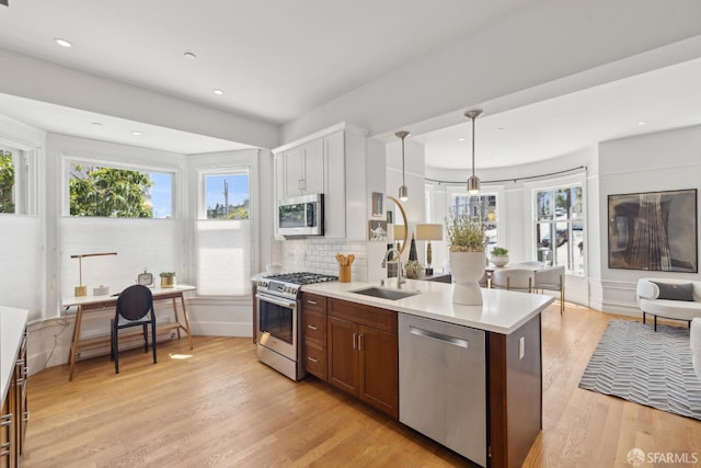 1500 Mcallister St Unit A, San Francisco, CA 94115 - kitchen with appliances with stainless steel finishes, light countertops, light wood-type flooring, a sink, and tasteful backsplash