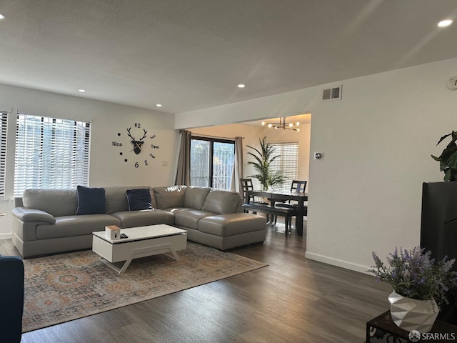 living room featuring dark wood-type flooring and a chandelier