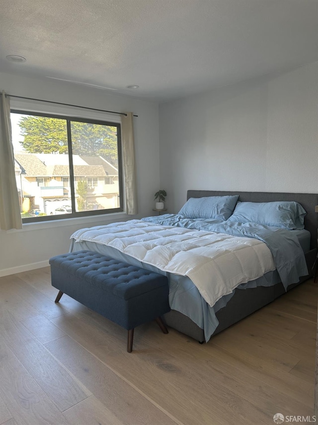 bedroom with wood-type flooring and a textured ceiling