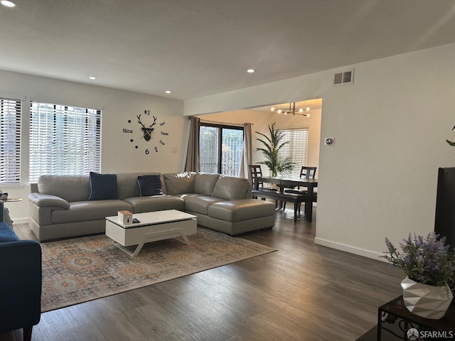 living room with dark hardwood / wood-style floors and a chandelier