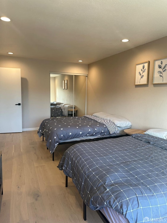 bedroom with wood-type flooring and a closet