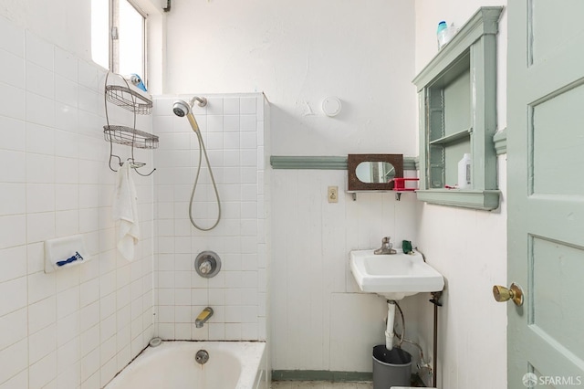 full bath with a sink, washtub / shower combination, and wainscoting