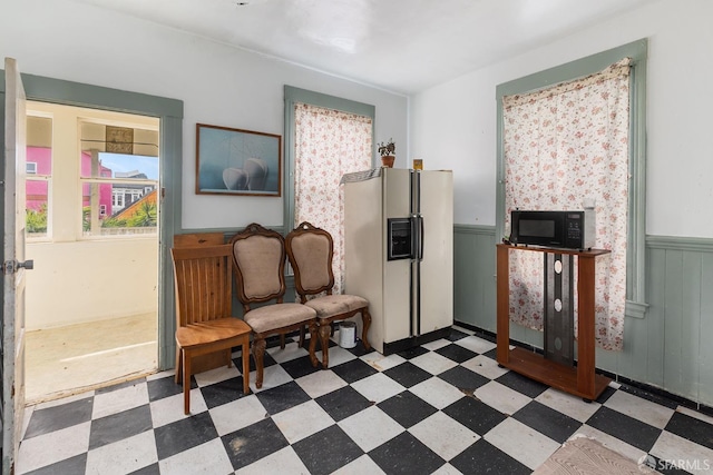 living area with tile patterned floors and wainscoting