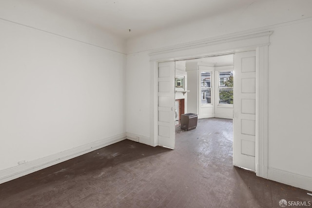 spare room featuring a fireplace and baseboards