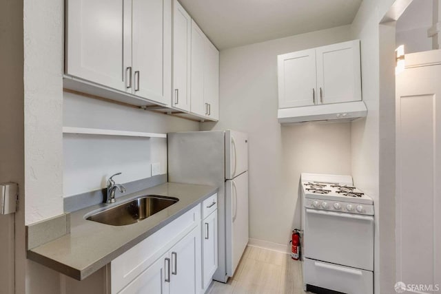 kitchen with a sink, white cabinetry, white appliances, and under cabinet range hood