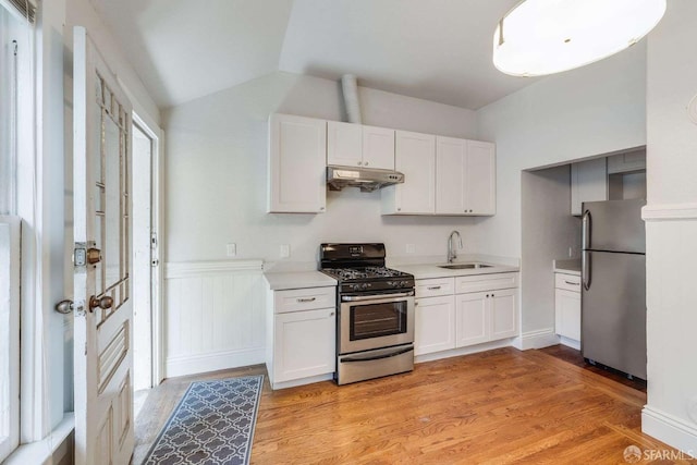 kitchen featuring light countertops, under cabinet range hood, stainless steel appliances, light wood finished floors, and a sink