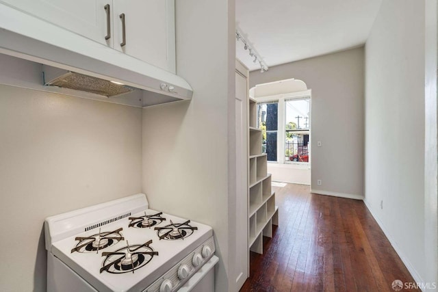 kitchen featuring baseboards, light countertops, white gas range, dark wood-type flooring, and rail lighting