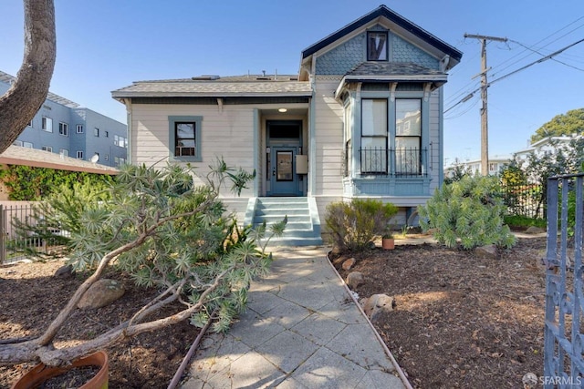 view of front of house featuring fence and a shingled roof