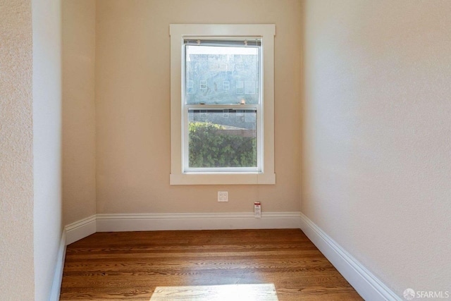 empty room featuring wood finished floors and baseboards