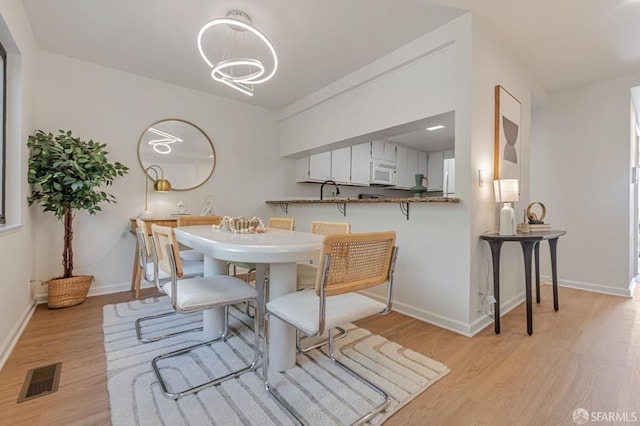 611 Stonegate Dr, South San Francisco, CA 94080 - dining room with light wood-style flooring, baseboards, and a chandelier