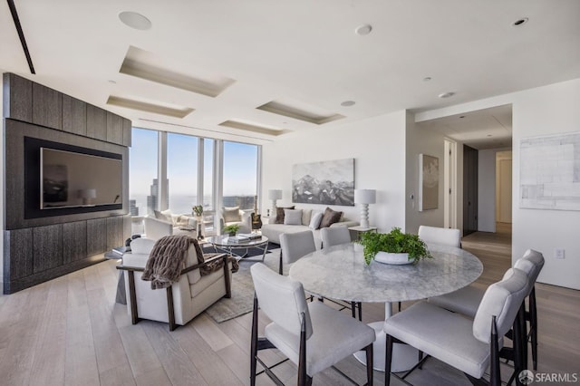 dining area featuring a wall of windows and light hardwood / wood-style flooring