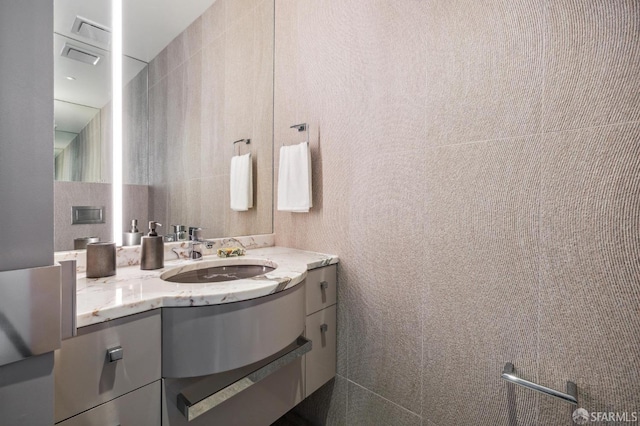 bathroom with tile walls and vanity