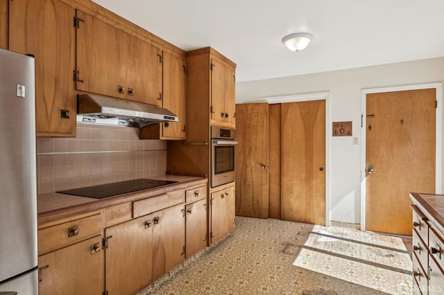 37 San Jacinto Way, San Francisco, CA 94127 - kitchen with under cabinet range hood, appliances with stainless steel finishes, tile countertops, tasteful backsplash, and brown cabinets