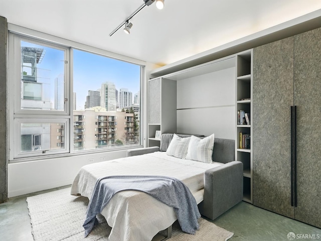 766 Harrison St Unit 711, San Francisco, CA 94107 - bedroom with finished concrete flooring, multiple windows, a city view, and track lighting