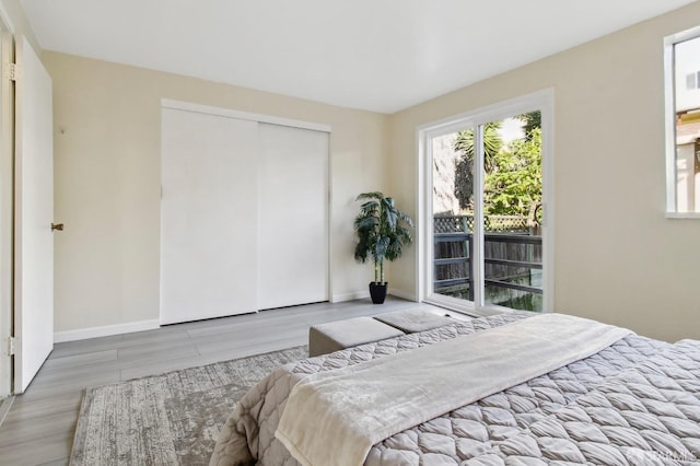 bedroom with access to outside, a closet, and light hardwood / wood-style floors