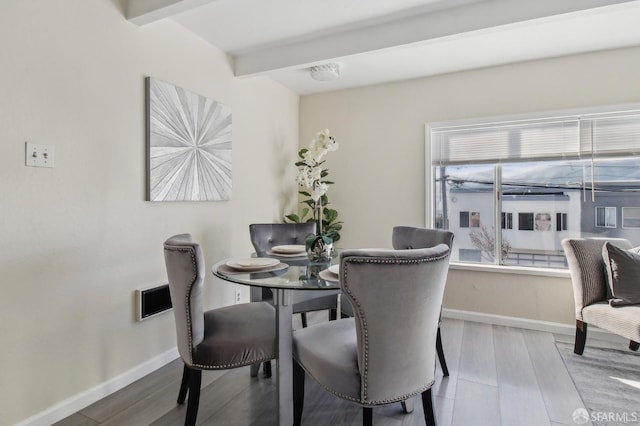 dining space featuring hardwood / wood-style flooring and beamed ceiling