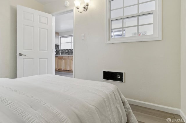 bedroom featuring light wood-type flooring and sink