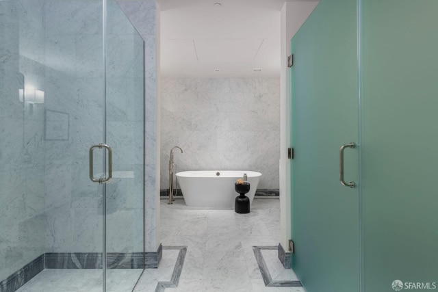 bathroom featuring a stall shower, tile walls, and a freestanding bath