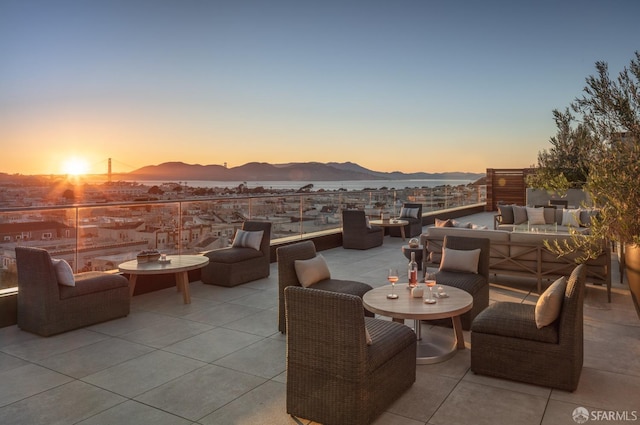 patio terrace at dusk featuring a mountain view and outdoor lounge area