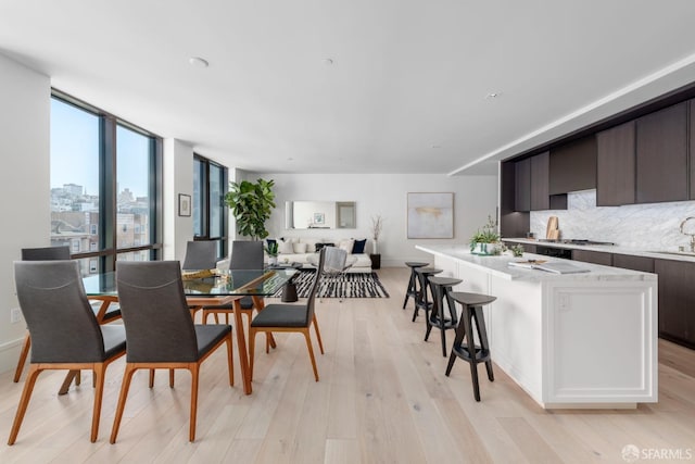 dining area featuring a wall of windows and light wood-style floors