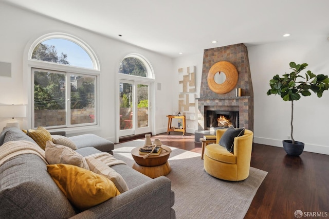 living room featuring recessed lighting, dark wood-style flooring, a fireplace, and baseboards