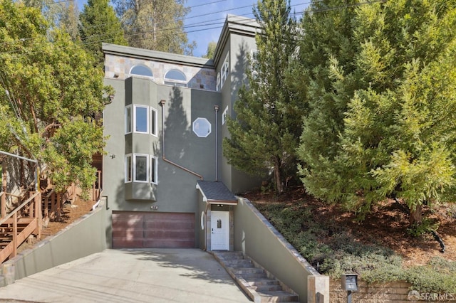 view of front facade with driveway, an attached garage, and stucco siding