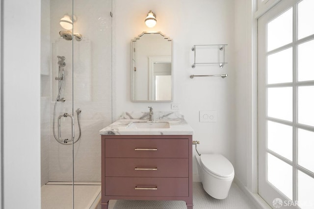 bathroom featuring tile patterned flooring, vanity, toilet, and a shower with door