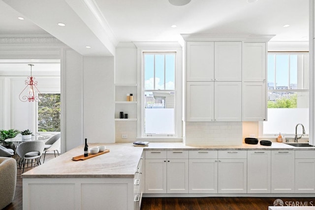 2500 Steiner St Unit 3, San Francisco, CA 94115 - kitchen featuring crown molding, white cabinetry, a peninsula, decorative backsplash, and light stone countertops