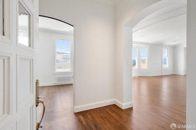 entryway featuring dark hardwood / wood-style flooring, crown molding, and radiator heating unit