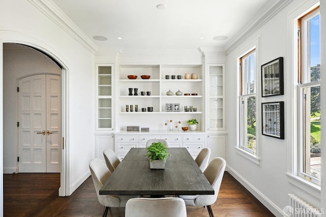 2500 Steiner St Unit 3, San Francisco, CA 94115 - dining room featuring radiator heating unit, arched walkways, dark wood-type flooring, and crown molding