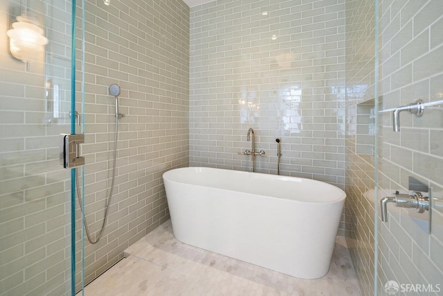 bathroom with tile patterned flooring, shower with separate bathtub, and tile walls