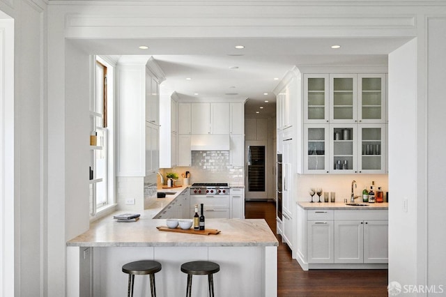 2500 Steiner St Unit 3, San Francisco, CA 94115 - kitchen with white cabinets, tasteful backsplash, dark wood finished floors, glass insert cabinets, and a peninsula