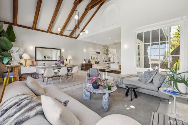 living room featuring a notable chandelier, high vaulted ceiling, beamed ceiling, and stairs